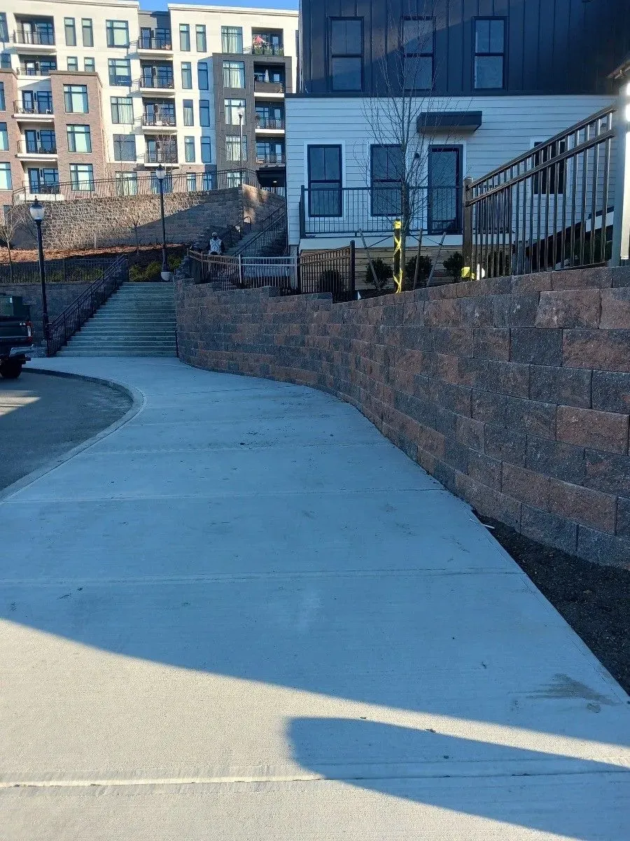 a concrete walkway leading to a building with stairs